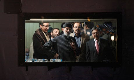 Tahir-ul-Qadri (centre) addresses his supporters from behind the window of his bomb-proof box