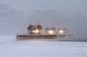 uk weather: Snow ploughs clear the runway at Gatwick Airport