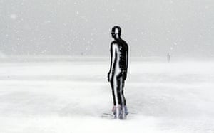 uk weather: Anthony Gormley's Another Place covered in snow on Crosby Beach 