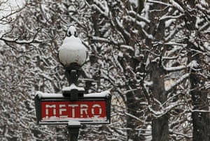 Paris snow: Snow covers a Metro sign and tree branches