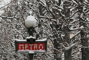 Paris snow: Snow covers a Metro sign and tree branches 