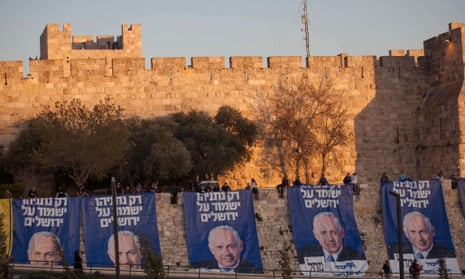 Likud party activists hang campaign posters of Israeli PM Binyamin Netanyahu that read: "Only Netanyahu will guard Jerusalem."
