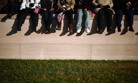 People sit on a wall on the National Mall.