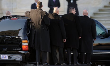 U.S. Secret Service agents ride on stepbar on the outside of their vehicle as they follow President Barack Obama as he leaves Capitol Hill.