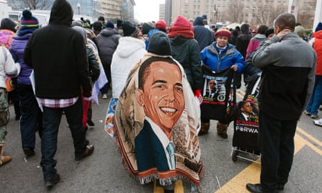 A woman covers herself in blanket with the picture of Obama, as she and others leave the Mall after the inaugural ceremonies.
