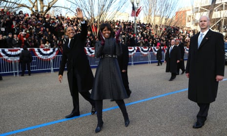 President Barack Obama and first lady Michelle Obama wave as they walk down Pennsylvania Avenue in Washington during the Inaugural Parade.