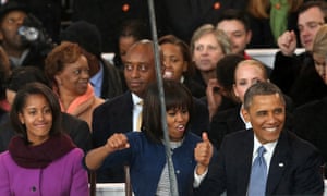 (L-R) Malia Obama, First lady Michelle Obama and U.S. President Barack Obama watch from the reviewing stand as the presidential inaugural parade winds through the nation's capital.