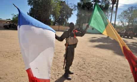 Malian soldier holds Mali and French flags