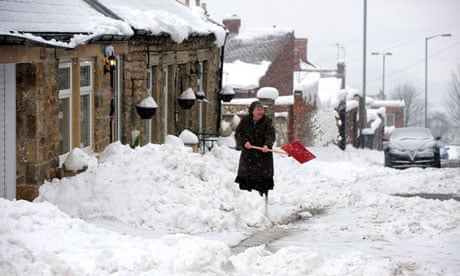 A woman clears the snow in Tanfield, County Durham