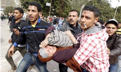 Protesters near Tahrir Square in Cairo help a woman overcome by teargas
