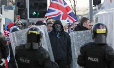 Police in riot gear try to contain loyalist protesters during clashes in Belfast over the union flag