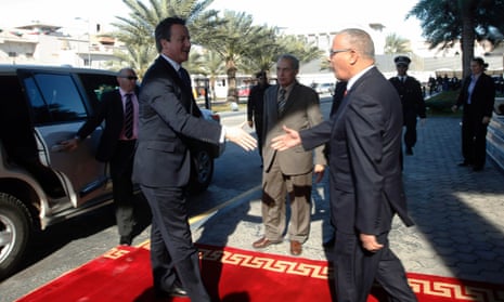 Libya's Prime Minister Ali Zeidan prepares to shake hands with Cameron as he welcomes him to the headquarters of the Prime Minister's Office in Tripoli.