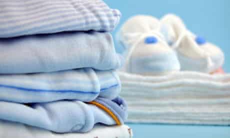 Pile of blue baby clothes and slippers on cotton diapers