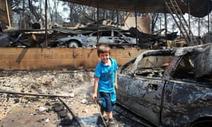 Lyndon Dunlop inspects the remains of his grandparent's home of 41 years destroyed by bushfire in Winmalee.