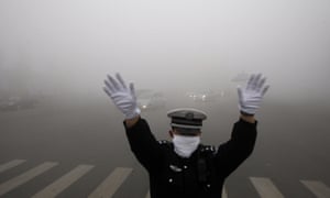 A policeman gestures as he works on a street in heavy smog in Harbin, China. Choking clouds of pollution blanketed Harbin, cutting visibility to 10 metres.