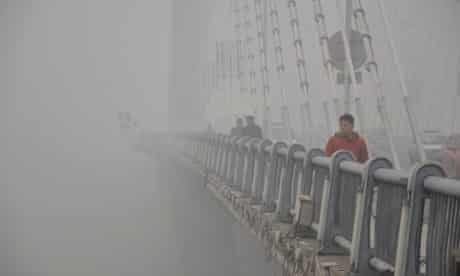 A pedestrian is picked out of gloom in his red jacket on a smoggy day in Jilin in China. Concern is growing over air quality in Chinese cities as the density of airborne particles is several times above World Health Organisation recommended limits.
