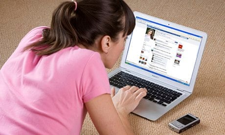 young woman looking at Facebook on laptop