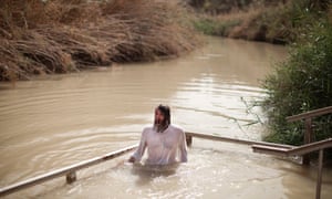 A Russian Orthodox pilgrim enters the water of the Jordan River for the baptismal ceremony at Qasr el-Yahud, Israel. Many Orthodox pilgrims visit the site where they believe that Jesus was baptised by John the Baptist.