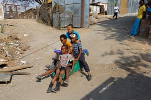 Alexandra Township: Young boys play on an old shopping trolly