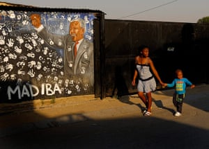 Alexandra Township: Girl and boy walk past a hand-painted mural