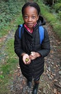 A child holding some acorns
