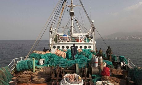 Sierra Leonean security forces supervise crew of a vessel caught for alleged illegal fishing in 2012