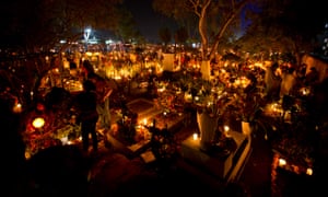People decorate the graves with flowers and candles during Day of the Dead celebrations in Oaxaca, Mexico. The holiday honours the dead and coincides with All Saints Day and All Souls' Day on 2 Nov.