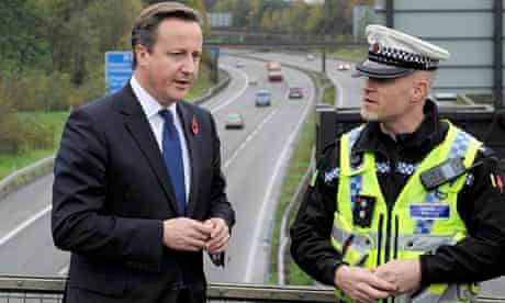 David Cameron speaks to Traffic Police Inspector Rob Gwynne-Thomas overlooking the M4 in Wales