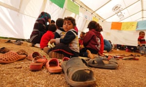 Syrian refugee children sit inside a makeshift school operated under UNICEF in a tent, in the Bekaa valley of Lebanon