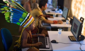 An indigenous child plays on a computer before the visit of Brazilian sport minister Aldo Rebelo to the XIIth games for Indigenous people, at the Botanic Garden in Cuiaba, Mato Grosso state in Brazil.