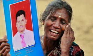 A Sri Lankan Tamil woman cries as she holds up a portrait of her missing son during a protest in Jaffna this morning. Hundreds of Tamil people protested in the northern Sri Lankan city before David Cameron's arrival, demanding answers about the thousands who went missing near the end of the war in 2009.