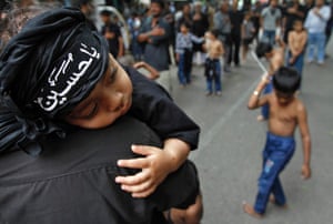 A Shi'ite Muslim boy wearing a scarf which reads "Oh Hussein" rests on the shoulder of a man as other boys flagellate themselves during a Muharram procession to mark Ashura in the southern Indian city of Chennai. Ashura, which falls on the 10th day of the Islamic month of Muharram, commemorates the death of Imam Hussein, grandson of Prophet Mohammad, who was killed in the seventh century battle of Kerbala.