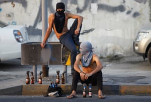 Anti-government protesters sit by the roadside with molotov cocktails as they wait for others to join during clashes after the Ashura procession in the village of Sanabis west of Manama. Hundreds of anti-government protesters, after finishing their Ashura procession, marched towards riot police and clashes, throwing molotov cocktails and strobes to which riot police responded with tear gas, bird-shots and stun-grenades to disperse them.