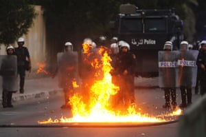 A molotov cocktail thrown by anti-government protesters bursts to flames in front of  riot police during clashes after the Ashura procession in the village of Sanabis west of Manama.