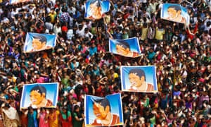 Schoolchildren wave and hold posters of Indian cricketer Sachin Tendulkar at an event to honour him at their school in Chennai, India