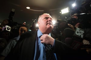 Under pressure: Mayor Rob Ford adjusts his tie as he makes his way to the council chamber in Toronto. The City Council voted overwhelmingly to strip Ford of some of his powers in the latest attempt to box in the brash leader who has rebuffed pressure to resign over his drinking and drug use.  Ford vowed to fight it in court. The council passed the motion 39-3.