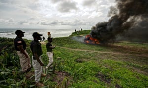 Liberia Drug Enforcement Agency officials look on as a recently seized stash of marijuana is burned in Paynseville, on the outskirts of Monrovia, Liberia. The marijuana was smuggled into the country from neighbouring Sierra Leone by a member of President Ellen Johnson Sirleaf's motorcade.