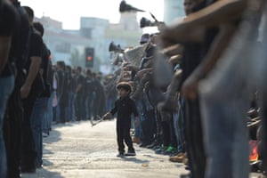 A young boy joins Shiite mourners as they mark the 11th day of Muharram in Daih village just outside the Bahraini capital Manama