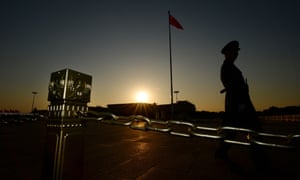 A Chinese para-military officer patrols Tiananmen Square in front of the Great Hall of the People (background) after the Communist Party Central Committee's concluded its secretive Third Plenum in Beijing on November 12, 2013.