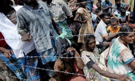 Internally displaced Sri Lankan people wait behind barbed wire during a visit by United Nations Secretary-General Ban Ki-moon in 2009.