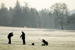 Two men play golf on a frosty morning in Kassel, Germany.