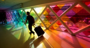 A lone traveler at the Miami International airport walks past a colorful art installation as he makes his way to the gate area. A line of storms heading toward the Mid-Atlantic and East Coast packing ice, sleet and rain could upset holiday travel plans for Americans as they hit the road, skies and rails for Thanksgiving.