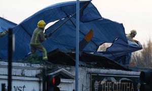 Rescue workers cover the wreckage of the police helicopter on the roof of the Clutha Vaults pub in Glasgow