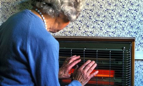 An old woman holding her hands near an electric fire