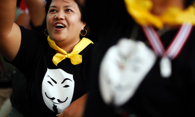 Protesters wearing Guy Fawkes t-shirts cheer during a rally against the amnesty bill in central Bangkok.