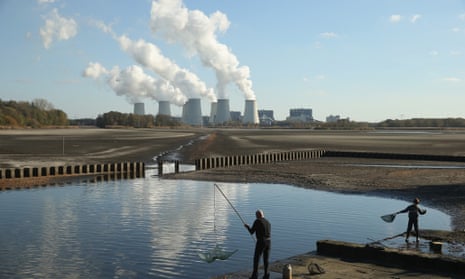 PEITZ, GERMANY - OCTOBER 31:  Fishermen cast nets as the cooling towers of the Jaenschwalde coal-fired power plant loom behind on October 31, 2013 in Peitz, Germany