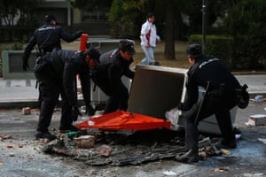Spanish police remove recycling bins that were blocking a street on the first day of an indefinite strike by street cleaners and park maintenance workers in Madrid.