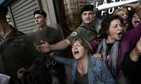 Greek protesters are pushed back as EU and IMF officials leave the Greek finance ministry