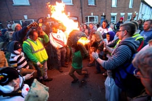 In action: A young boy picks up a burning barrel soaked in tar in Ottery St Mary, Devon, England.