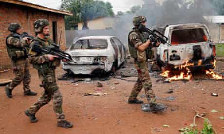 French troops patrol past two rebel vehicles set on fire in Bangui, Central African Republic